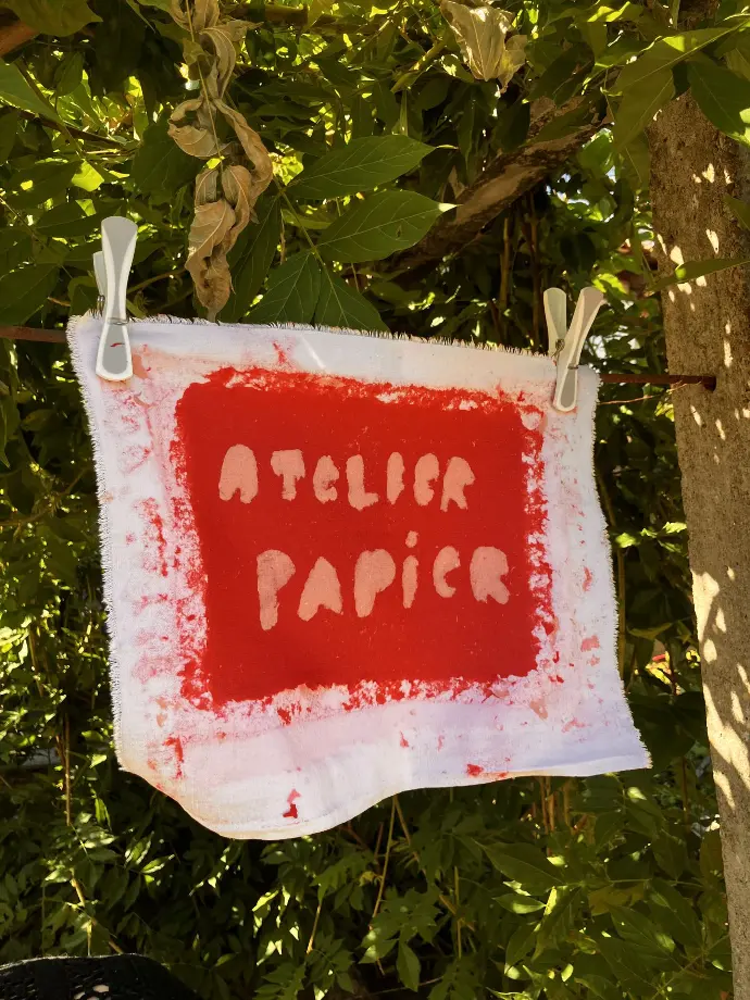 Feuille de papier recyclé en train de sécher avec les mots "Atelier papier" créé directement dans la feuille avec de la pulpe