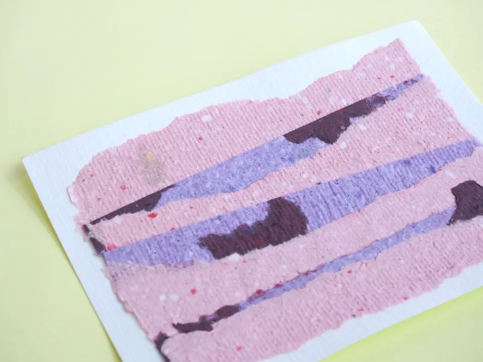 Carte postale composée de papier recyclé violet et rose découpé